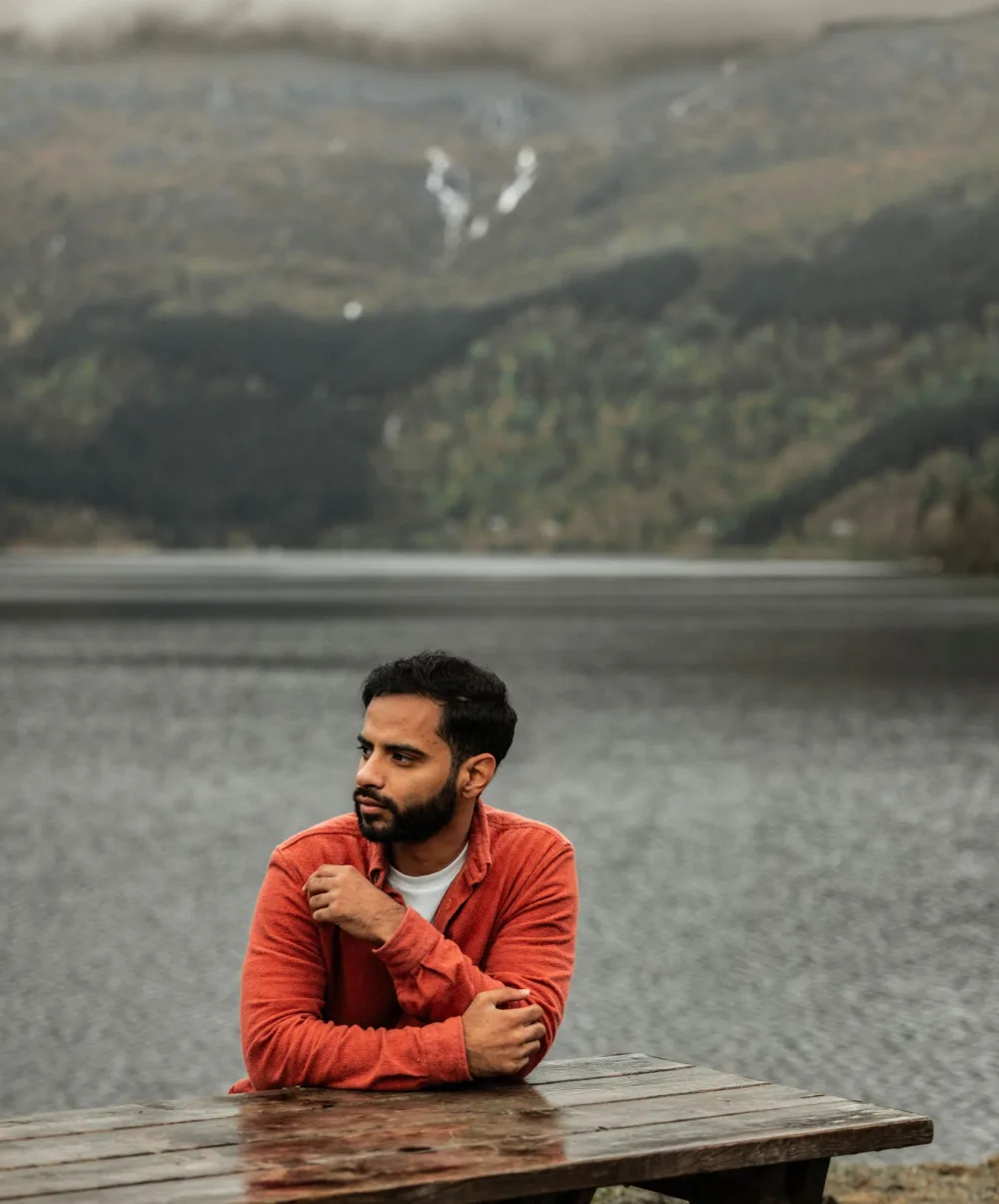Ishaq of IS Films, at a lakeside table below misty hills